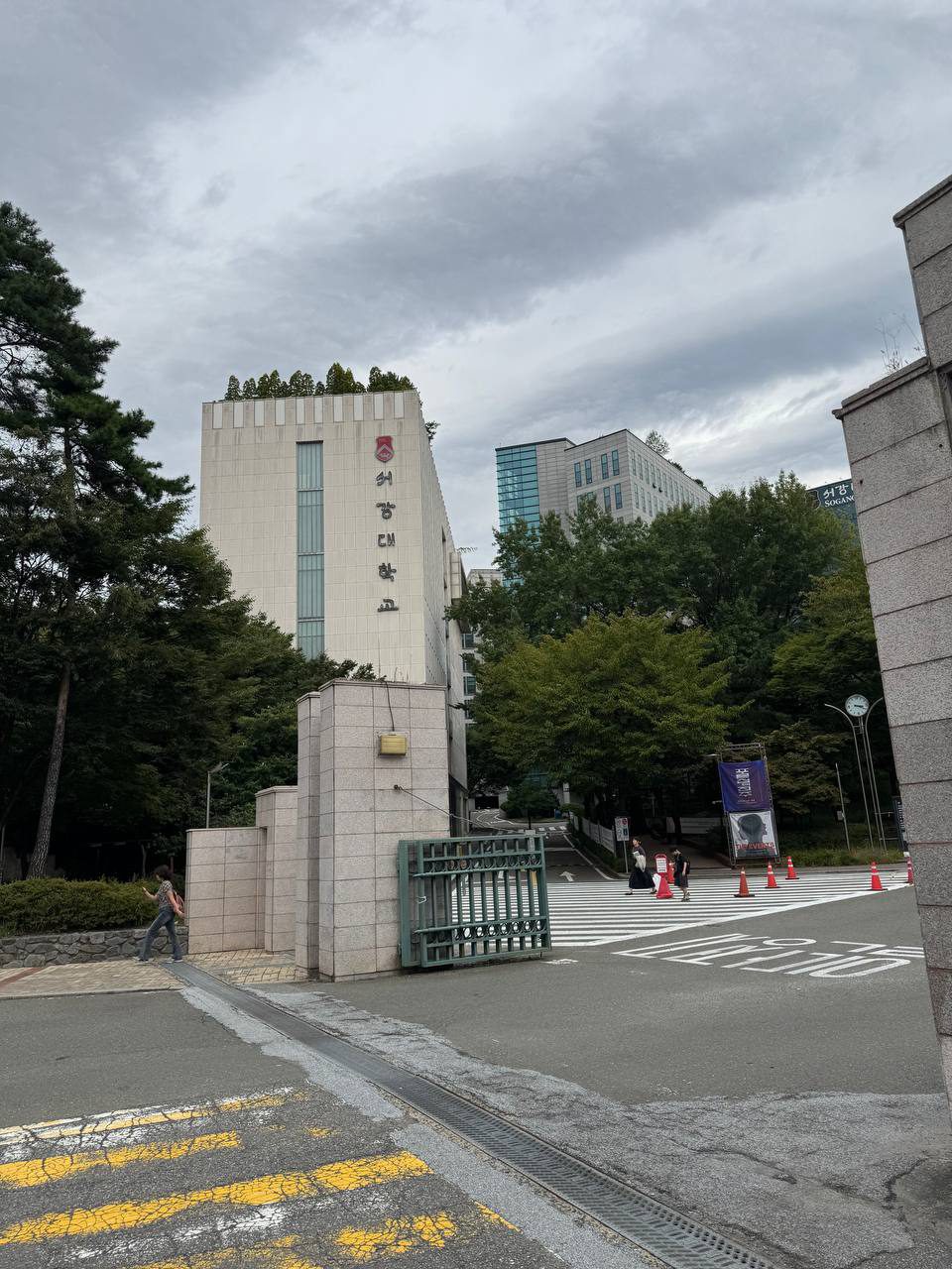 흰색 외벽에 붉은 교표와 서강대학교 세로 글씨가 붙은 건물, 옥상에 나무가 심겨 있다